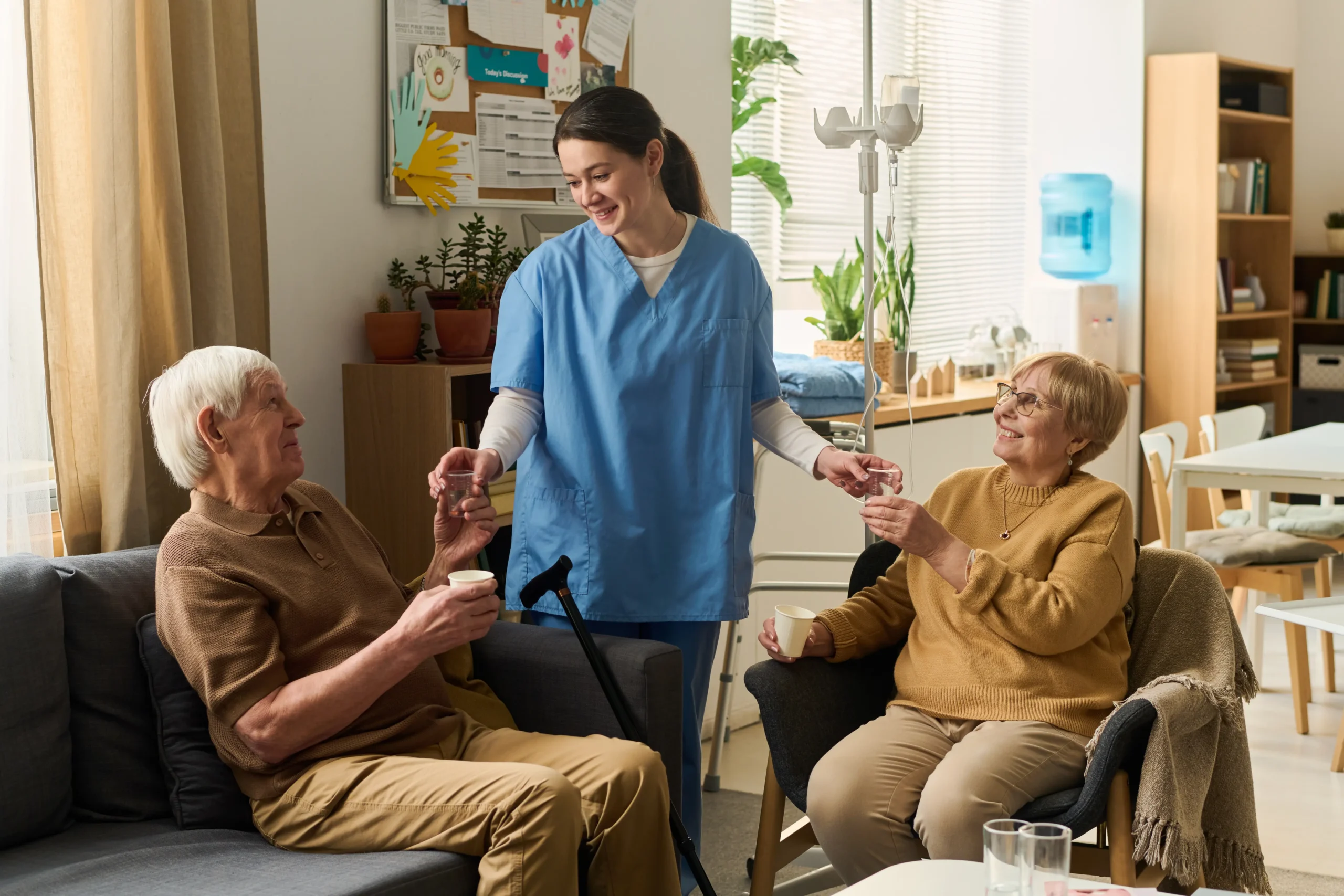Caregiver helping a senior couple with medication at home
